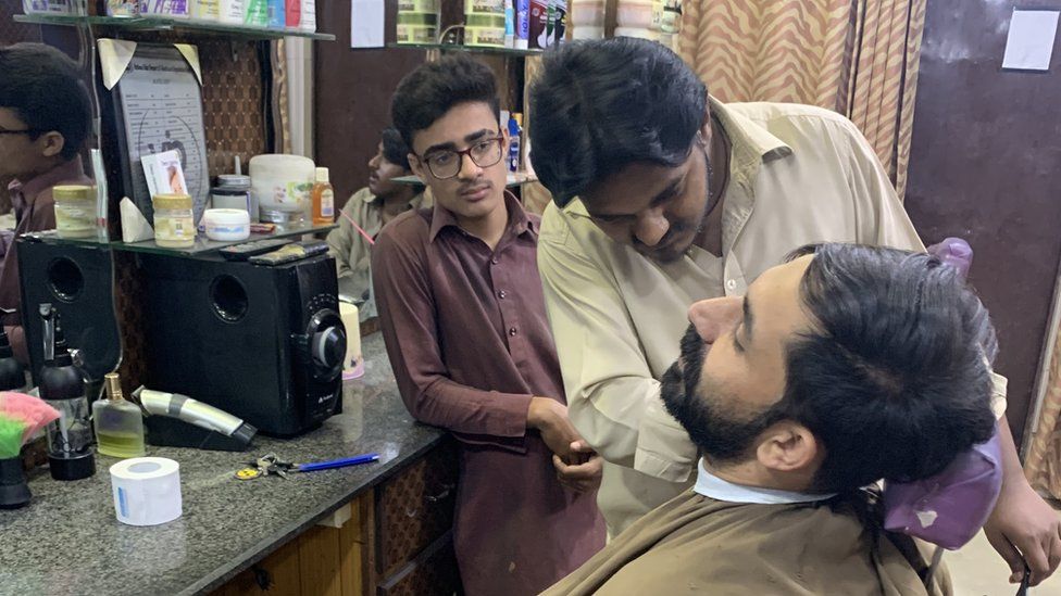 Mujahid Ali at work in his Islamabad barber shop.