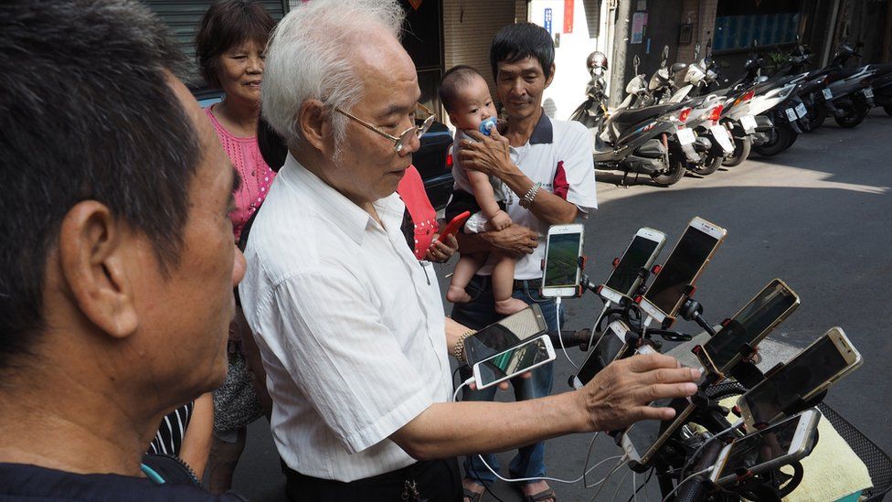 Chen San-yuan shows his Pokemon Go set up to passersby