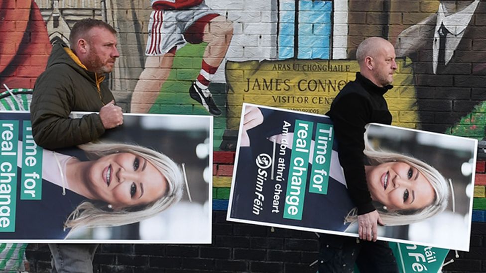Sinn Féin election workers carry election posters on the Falls road April 25, 2022 in Belfast, Northern Ireland
