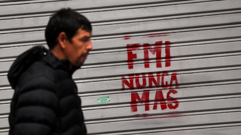 Man walks past graffiti reading "IMF never again" in Buenos Aires, 1 June 2018