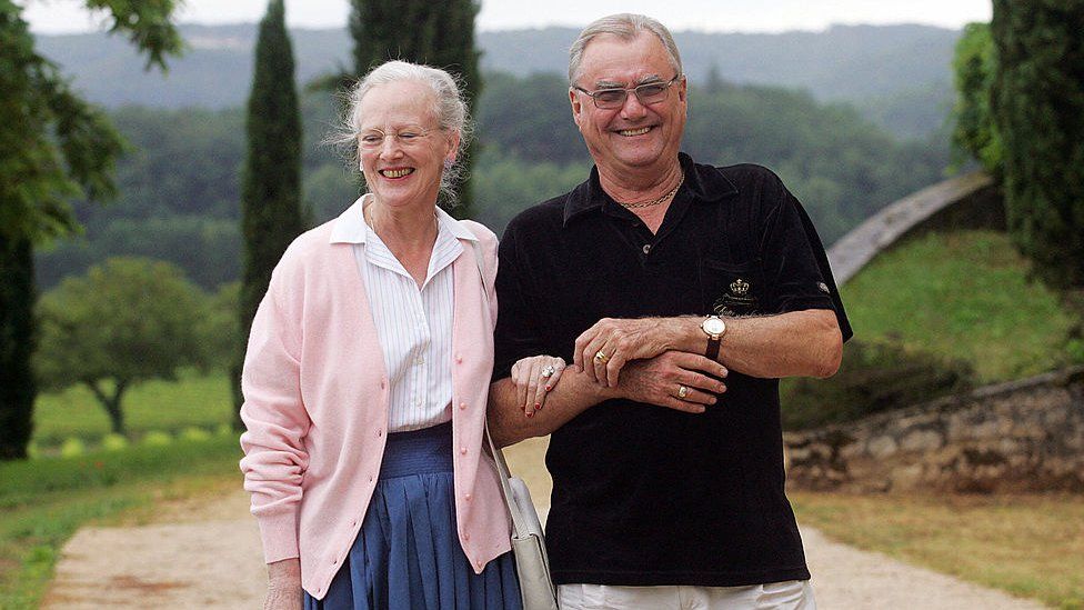 Queen Margrethe II walks arm-in-arm with Prince Henrik of Denmark