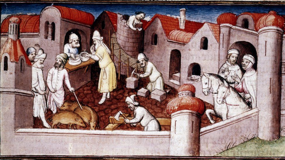Scene from Marco Polo's Book of Marvels, early 15th century, showing merchants entering a walled town, mason and carpenter at work, a shopkeeper serving a customer, and men driving swine
