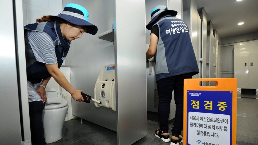 Two women checking toilets in Seoul