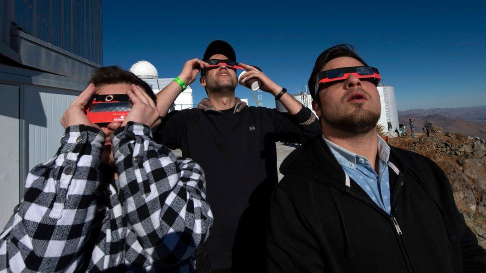 People watch a solar eclipse at La Silla European Southern Observatory (ESO) in La Higuera, Coquimbo Region, Chile