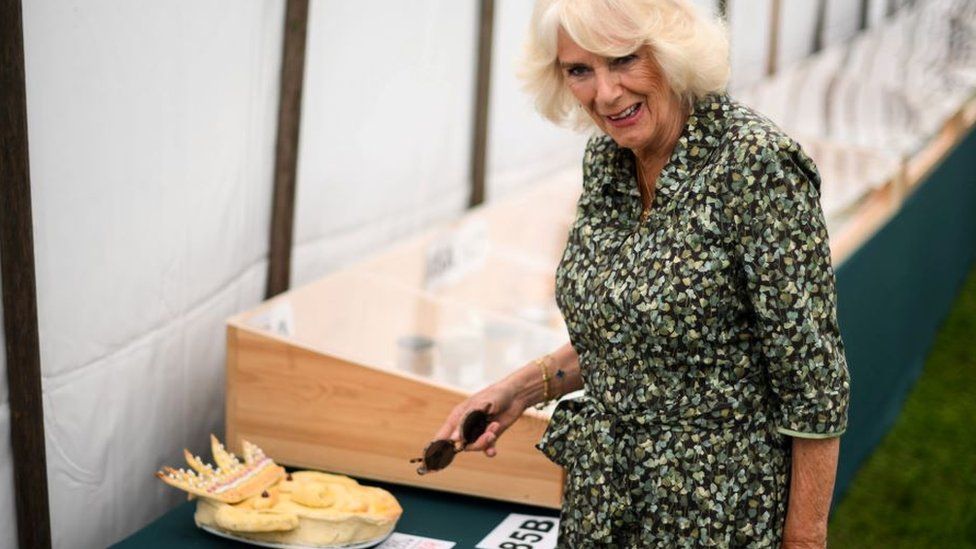 Queen Camilla looking at some pies