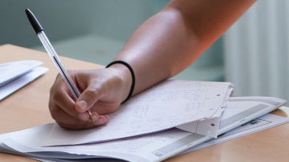 Girl taking exam close up of hand and paper