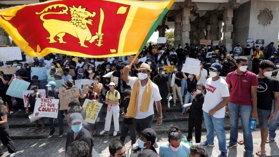 People shout slogans and wave the Sri Lankan flag during a protest against the president mid the country's economic crisis, at Independence Square in Colombo