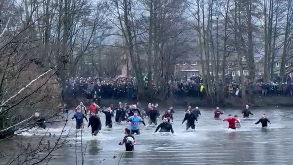 Players chase the ball in the water