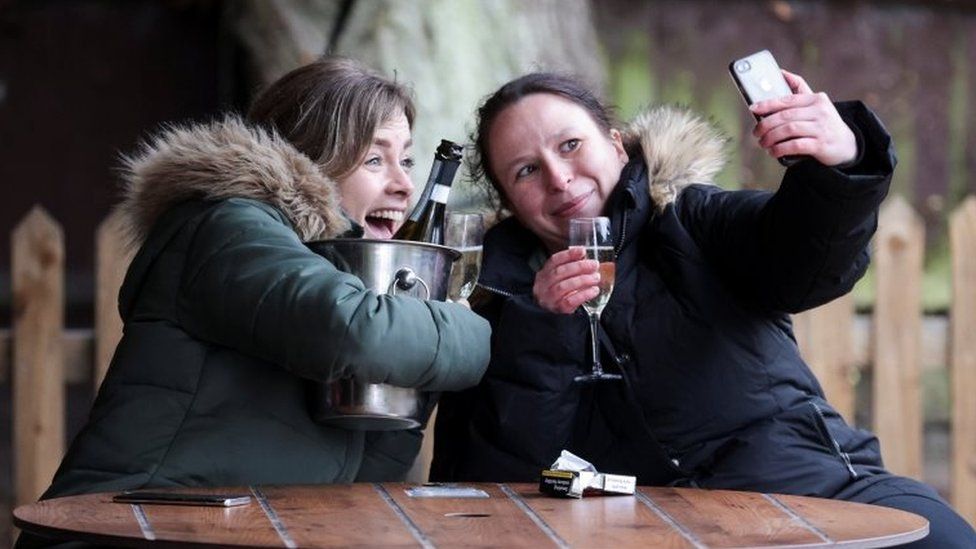 Women take a selfie with their drinks at The Fox on the Hill pub in London
