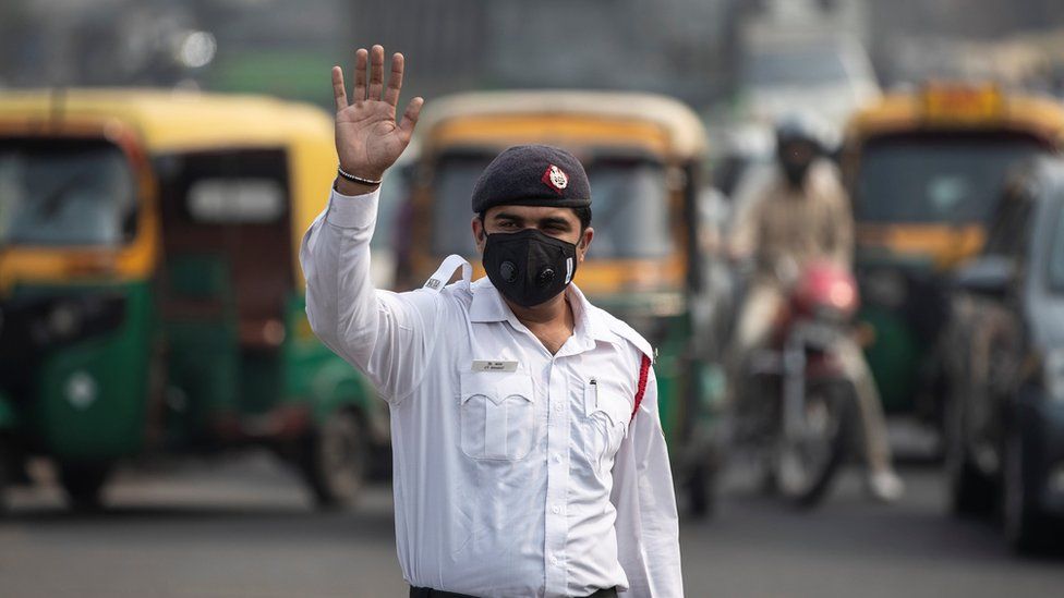 A traffic policeman wears a mask to protect himself from air pollution at a junction during restrictions on private vehicles based on registration plates, on a smoggy morning in New Delhi, India, November 4, 2019.