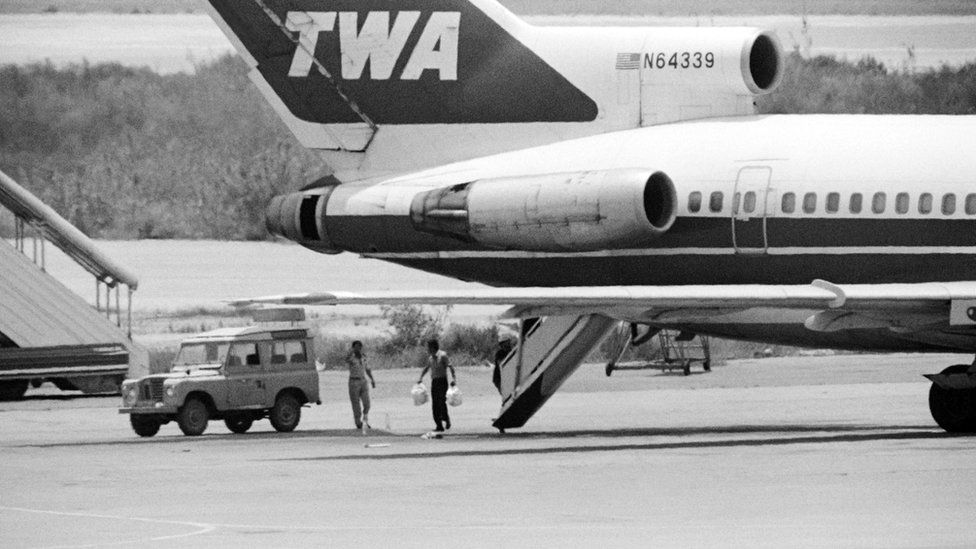 A Lebanese employee at Beirut airport takes bags of sandwiches on board of TWA Flight 847