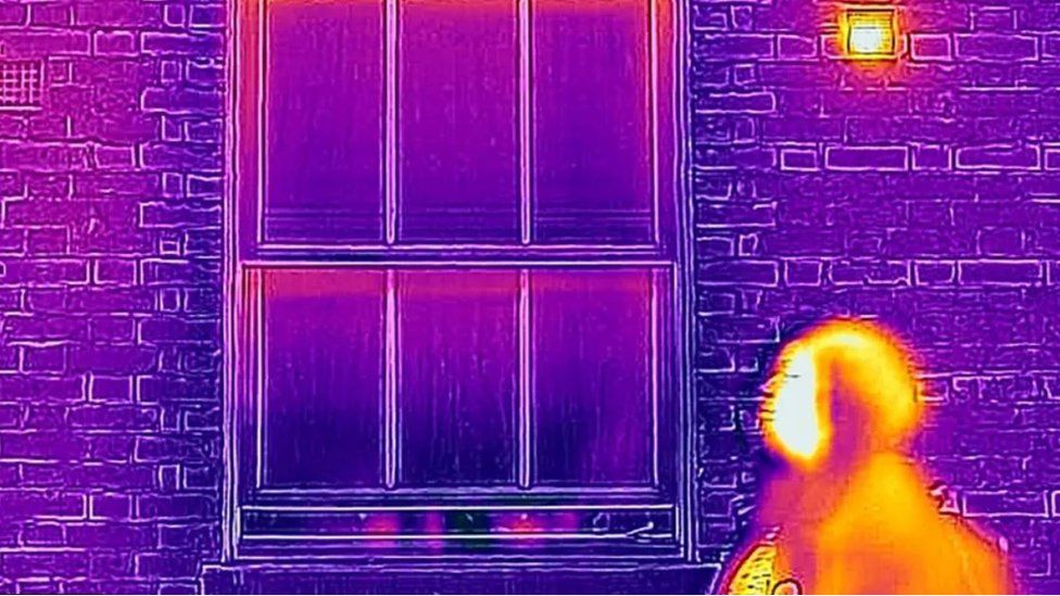 Image of woman and house using thermal camera