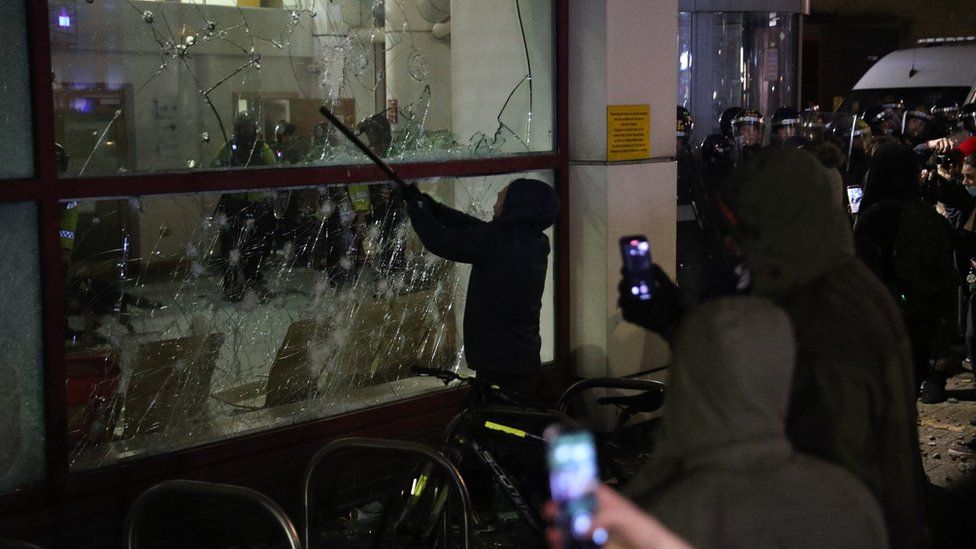 Police station window being smashed