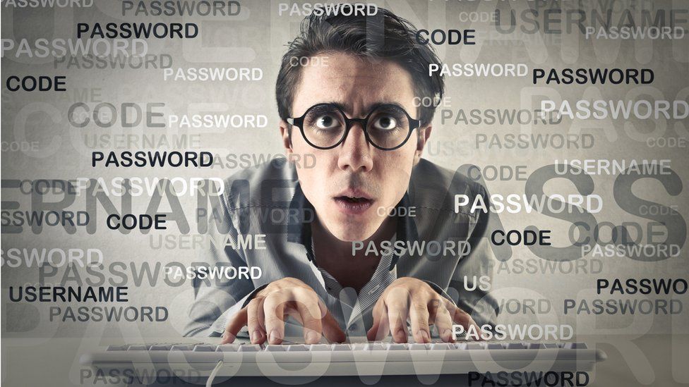 Geeky man typing on keyboard surrounded by password graphics