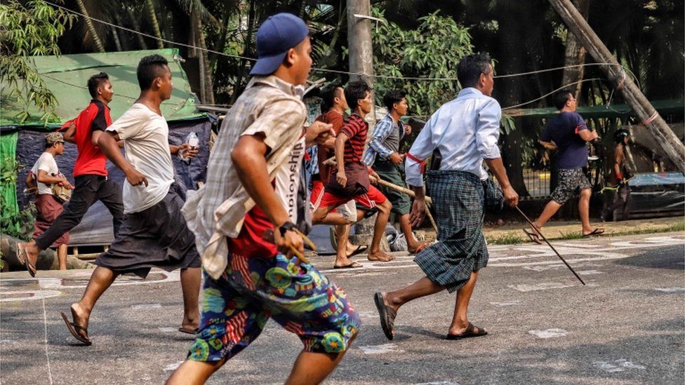 Люди сталкиваются с силами безопасности, продолжая протестовать против военного переворота и задержания избранных членов правительства в поселке Хлаинг Тхар Яр, Янгон, Мьянма, 14 марта 2021 г.