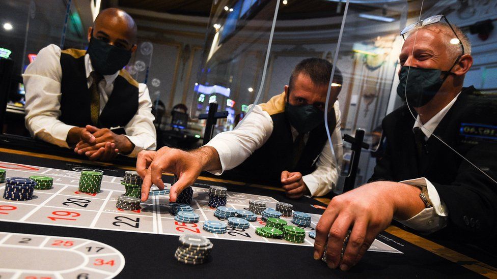 Staff wearing personal protective equipment run through a game of roulette at The Rialto casino in central London