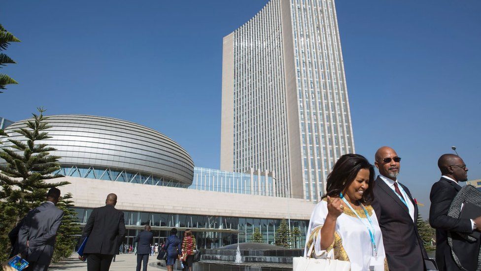 Delegates arriving to attend the 28th African Union (AU) Heads of State Summit are pictured against a background of the AU hearquarters prior to the opening ceremony on January 30, 2017 in Addis Ababa