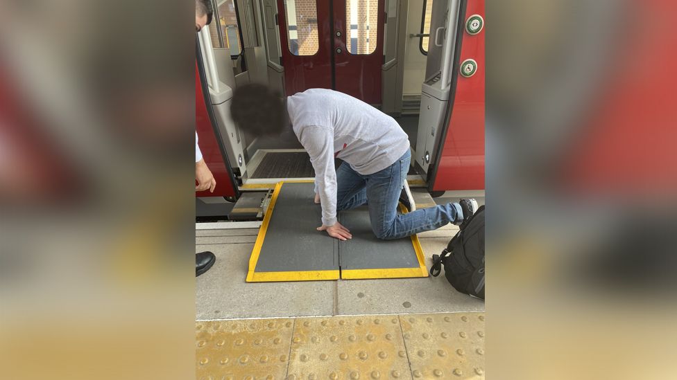 Marie Blackett's husband looking at a train ramp at Peterborough railway station