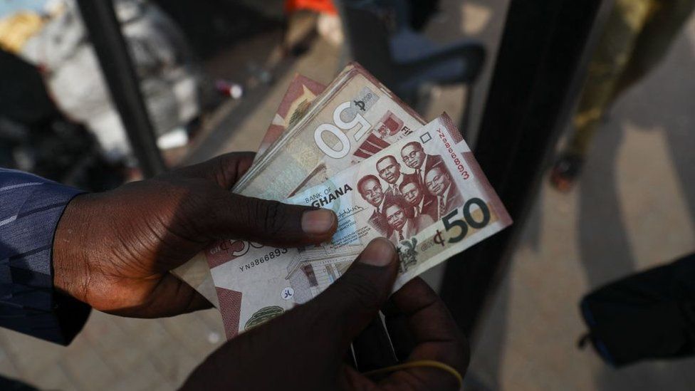 Man holds Cedi notes
