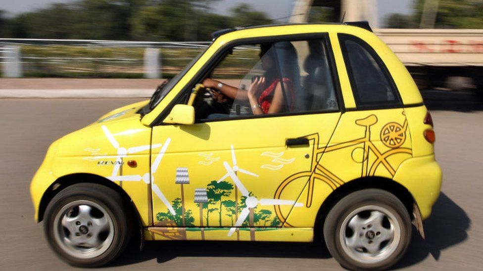 Members of the Indian Youth Climate Network drive A solar powered Reva electric car in New Delhi