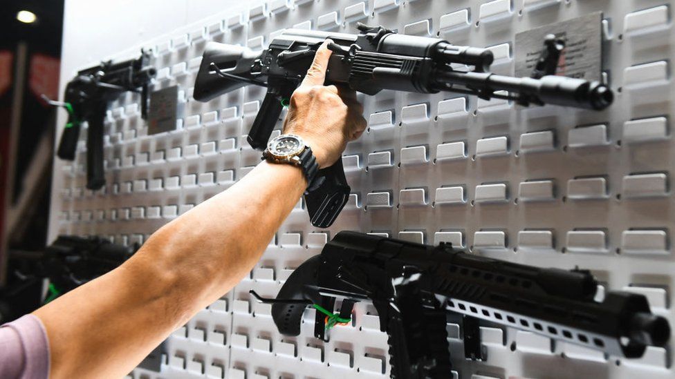 An attendee at the 2022 NRA annual meeting in Texas looks at semi-automatic rifles