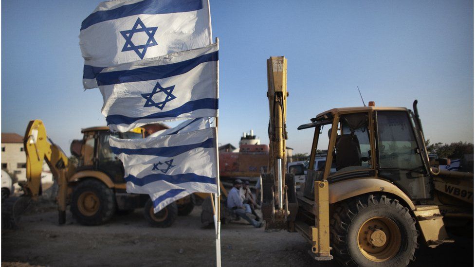 Israeli flags and construction machinery at Adom settlement (file photo)