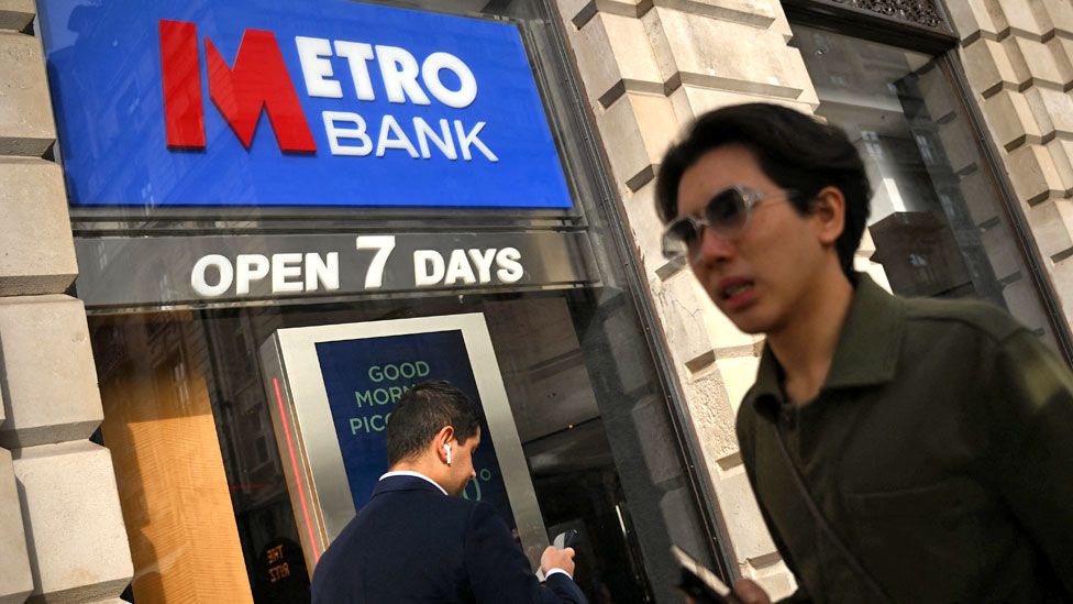 Pedestrians pass a branch of British bank Metro Bank in central London on 6 October 2023