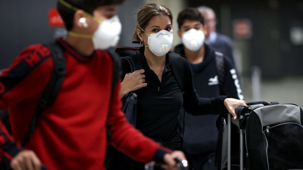 Passengers wearing face masks at an airport terminal