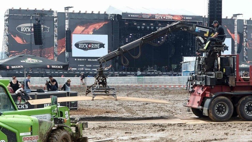 A worker lifts a board at the Rock am Ring music festival (04 June 2016)