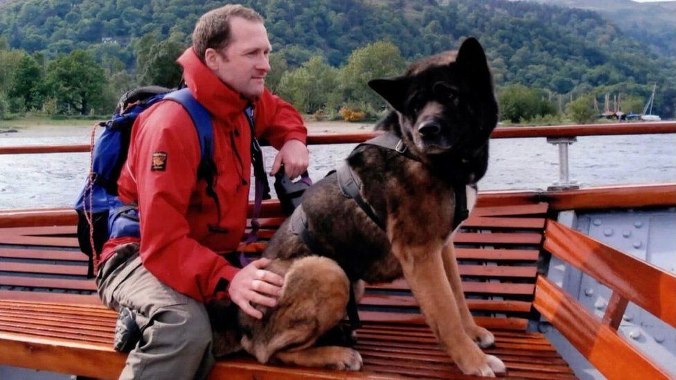 A man in a boat with a large dog