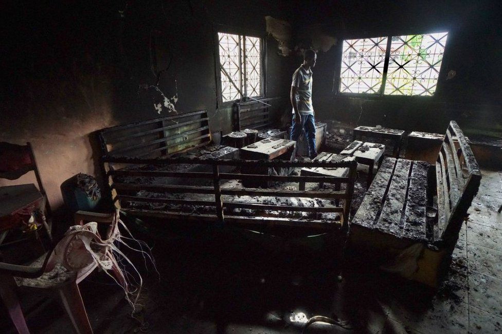 Мужчина ходит в сгоревший ресторан в 2019 году, который был разрушен в ходе боев между вооруженными англоязычными сепаратистами и камерунскими военными.