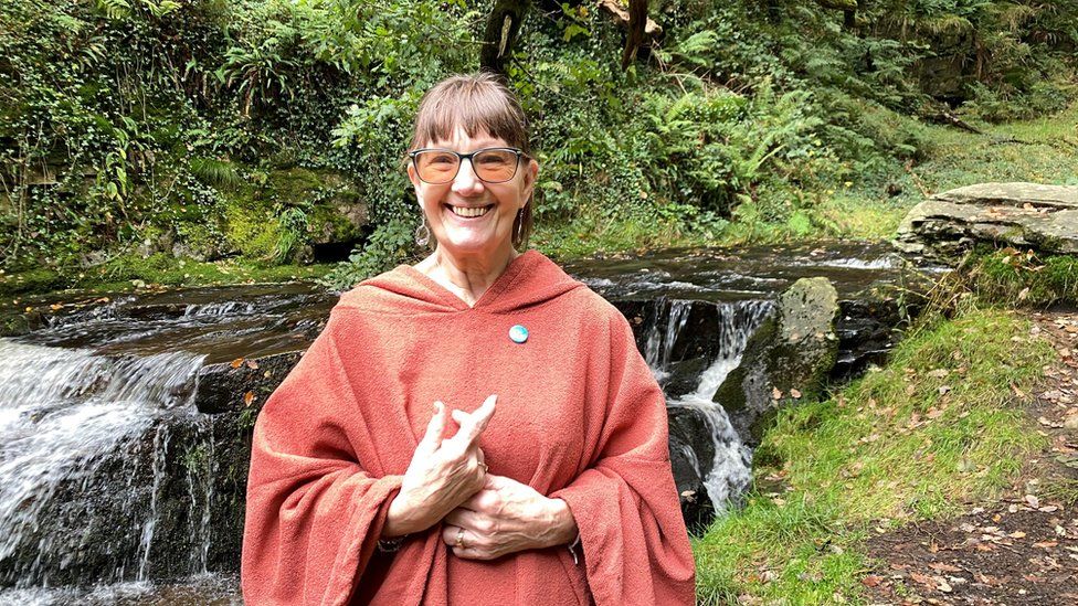 Elaine Bowen in a dry robe by the waterfall