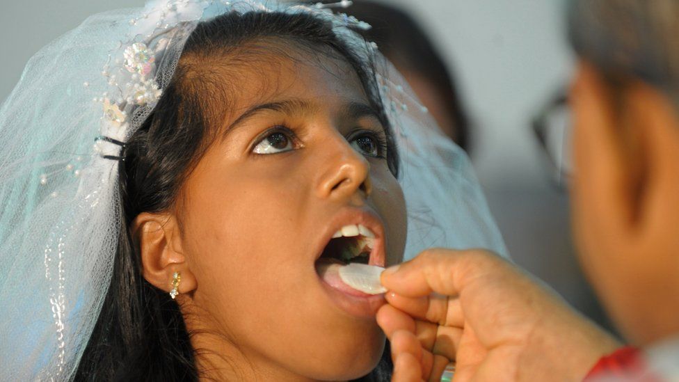 A girl receives her First Holy Communion from Indian Catholic Archbishop Thumma Bala at the Mount Caramel Church in Hyderabad on July 22, 2012.