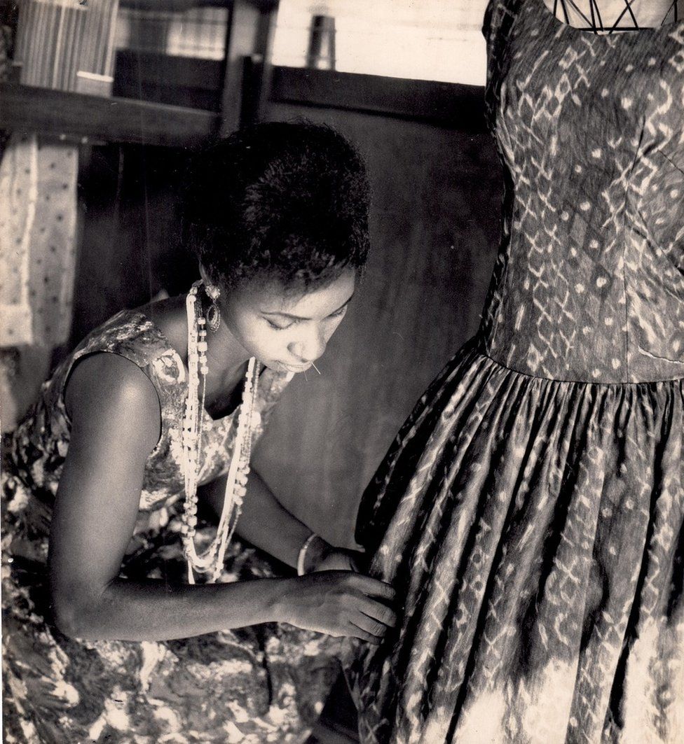 Женщина работает над платьем