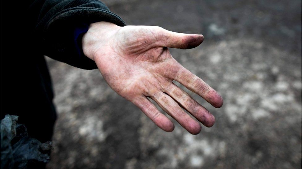 A farmer shows her hand covered with black dust in Saint Martin-du-Vivier, near Rouen, 30 September 2019