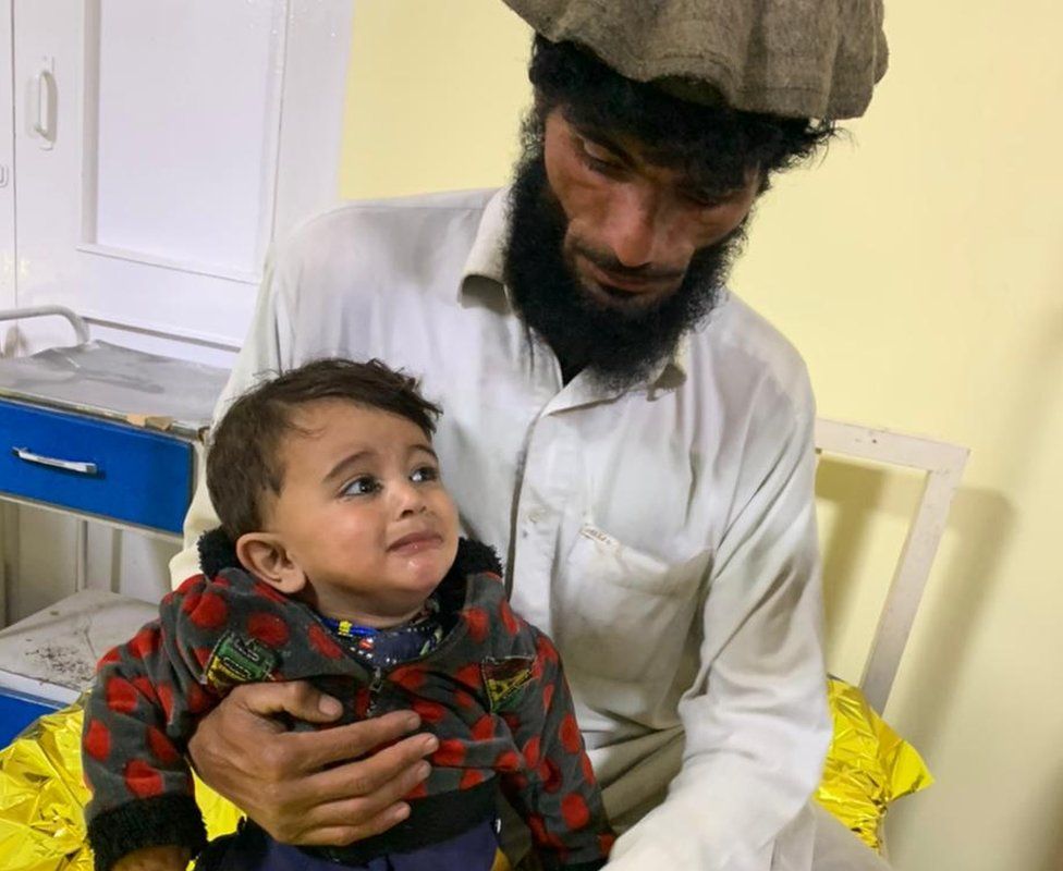 Афганец держит маленького мальчика в больнице