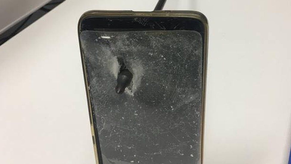 The man's damaged phone seen with an arrow through it