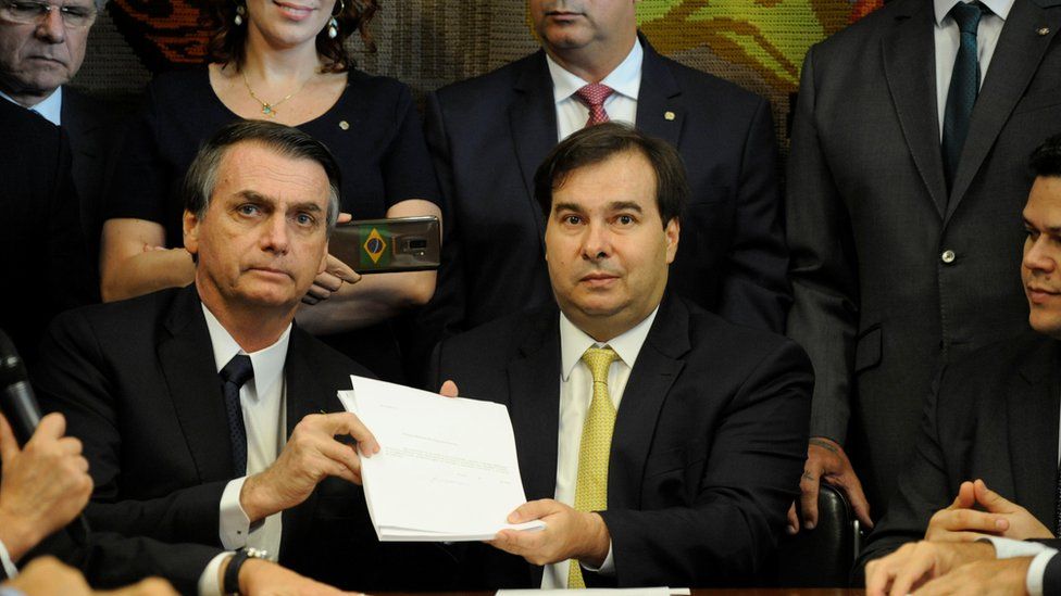 Brazil's President Jair Bolsonaro and Lower House President, Rodrigo Maia pose with the proposal of the pension system reform bill at the National Congress in Brasilia, Brazil February 20, 2019