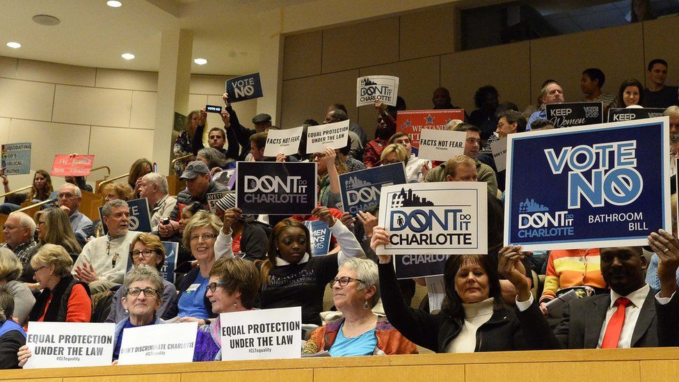 Audience holds up signs at ordinance debate