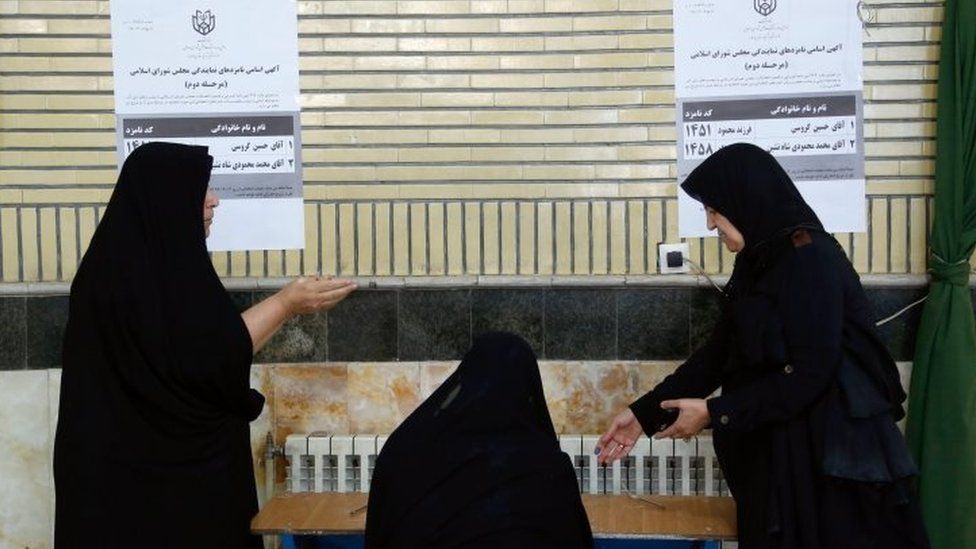 Iranian women fill their ballot to vote in a polling station during the second round of parliamentary elections at the Jameh Mosque in the city of Shahre Ghods (29 April 2016)