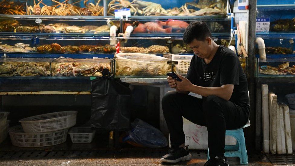 A vendor at a wholesale fish market in Beijing