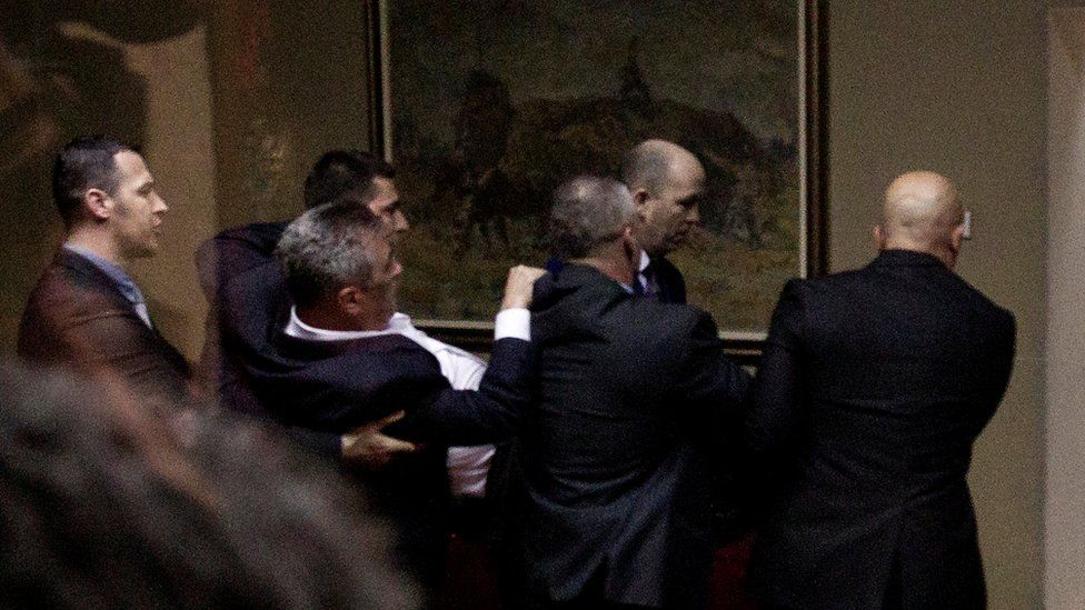 Police officers carry away opposition deputy Slaven Radunovic from the Democratic Front