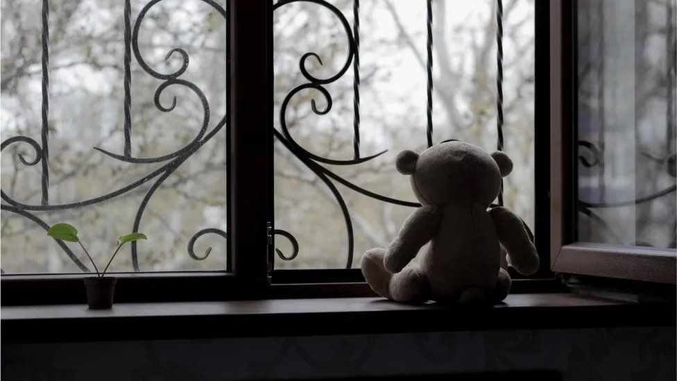 A child's toy looking out a window