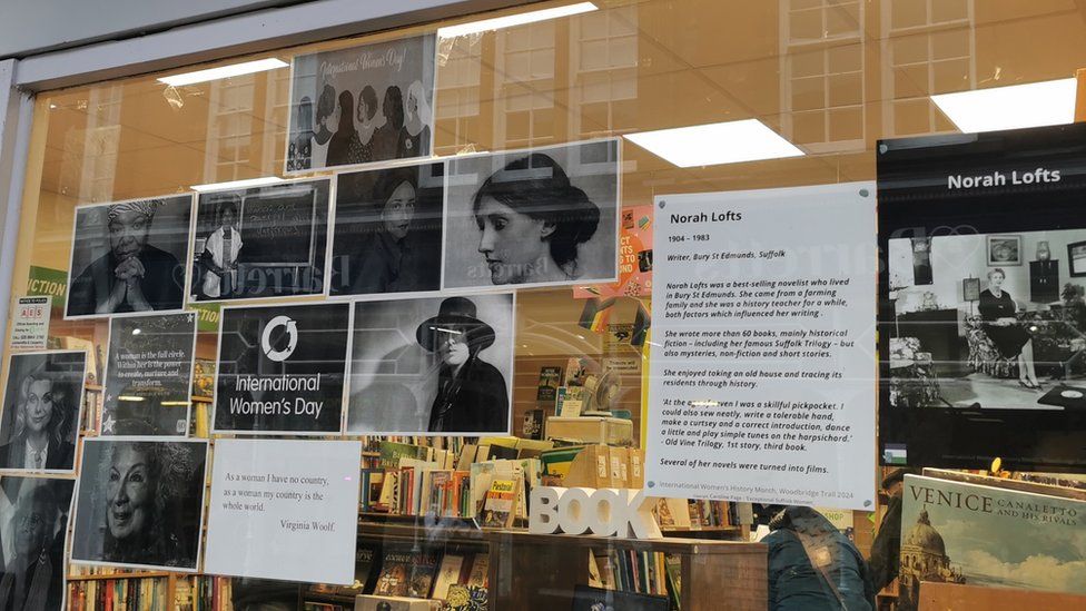 A shop window containing information and photographs of historial women