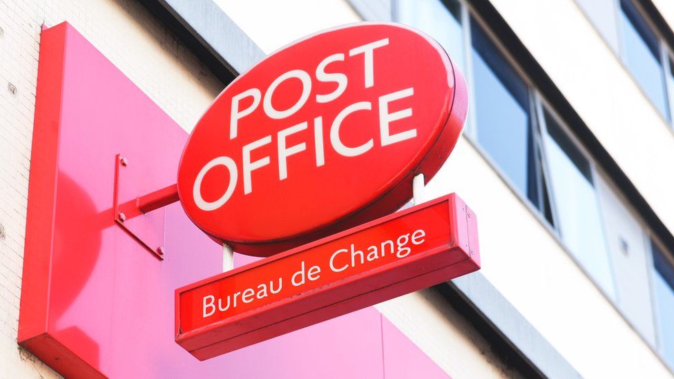 A Post Office sign on the outside of a building