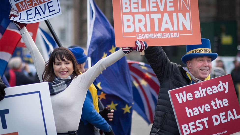 Pro and anti-Brexit campaigners wave placards outside Parliament