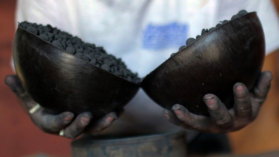 A firework maker holds gunpowder up to the camera in Mexico