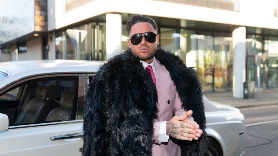 Stephen Bear dressed in a pink suit and tie with black fur coat outside Chelmsford Crown Court in 2023