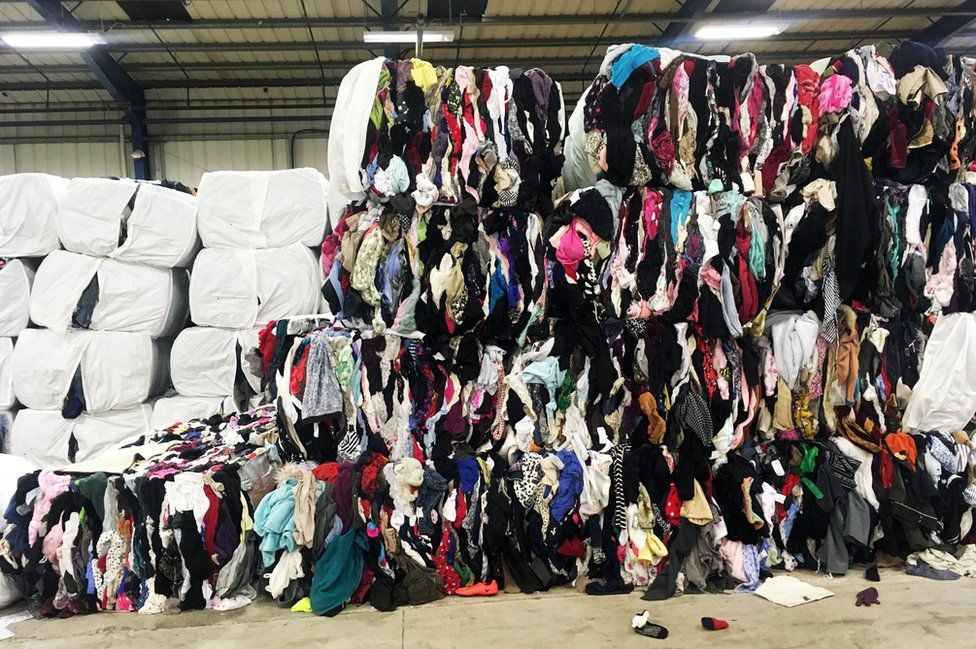 Bales of clothes at Oxfam recycling centre
