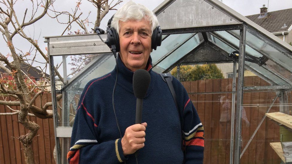 Terry with headphones and radio mic looking around his restored greenhouse